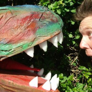 Actor looking worryingly into mouth of T-rex