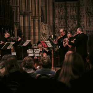 The Kernow Chamber players perform in a dimly lit church setting.